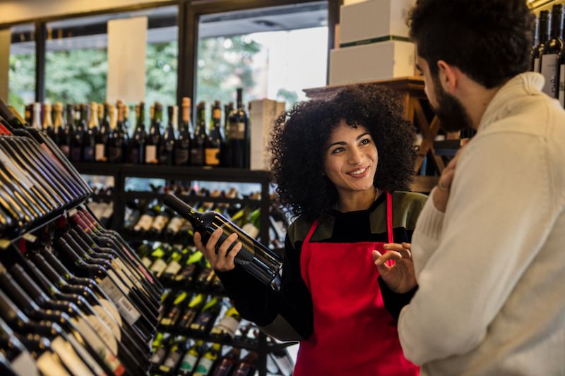 Liquor & Grocery Wine Shops dark pic Clerk helping man pick out wine